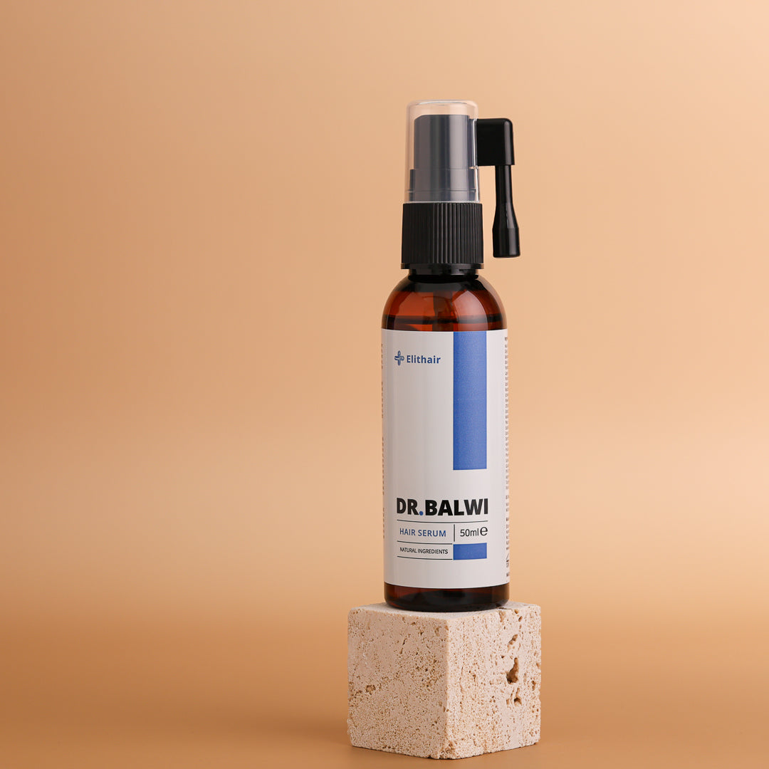 Eine braune Flasche Dr. Balwi Haarserum aus dem Hair Boost Set von shop.elithairtransplant steht auf einem hellen Steinblock mit schlichtem beigem Hintergrund. Das weiße Etikett trägt blau-schwarzen Text, der Procapil™ und AnaGain™ hervorhebt.