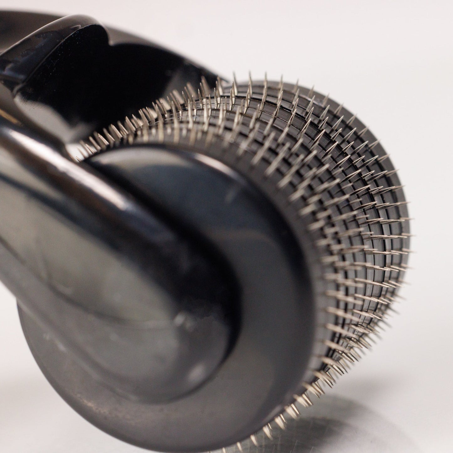 Nahaufnahme des Dr. Balwi Dermarollers aus dem Dr. Balwi Shop mit vielen winzigen Metallnadeln auf einem zylindrischen Roller, der fĂŒr Hautpflegebehandlungen und Microneedling zur UnterstĂŒtzung des Haarwachstums entwickelt wurde.