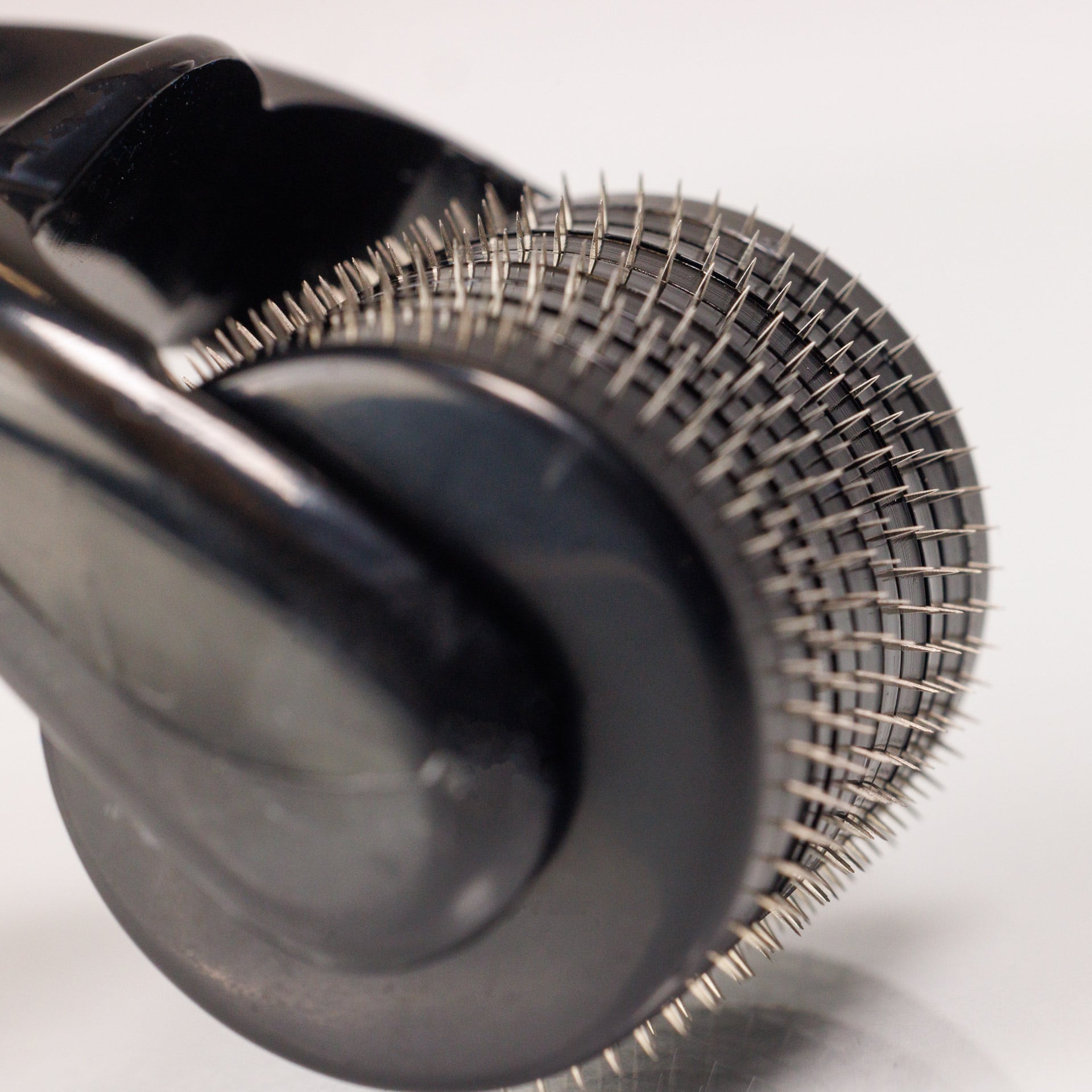 Nahaufnahme des Dr. Balwi Dermarollers aus dem Dr. Balwi Shop mit vielen winzigen Metallnadeln auf einem zylindrischen Roller, der fĂŒr Hautpflegebehandlungen und Microneedling zur UnterstĂŒtzung des Haarwachstums entwickelt wurde.
