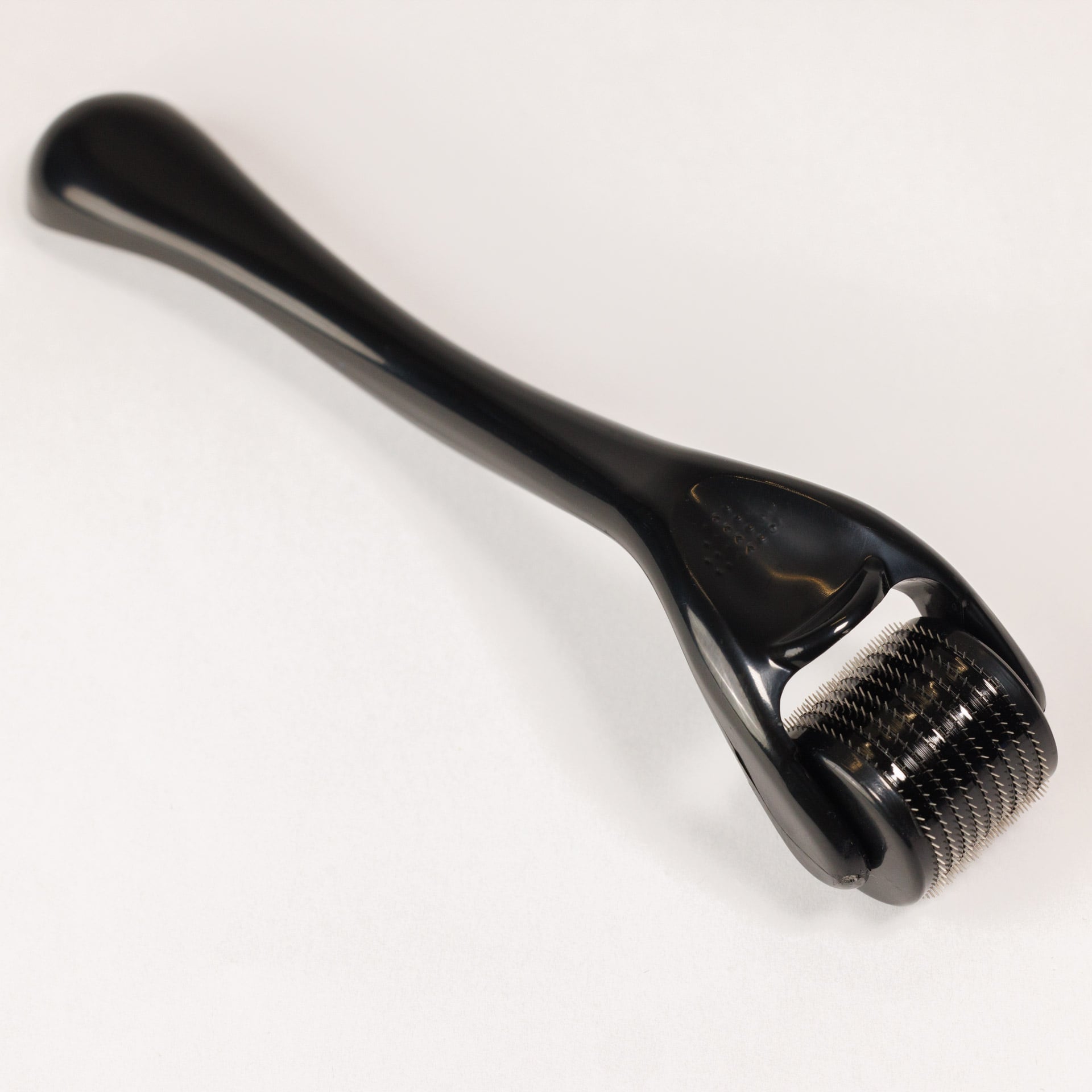 Der Dr. Balwi Dermaroller von Dr. Balwi Shop ist ein schwarzes Microneedling-Tool mit nadelbesetztem Roller und langem Griff - perfekt fĂŒr die HautverjĂŒngung und zur UnterstĂŒtzung des Haarwachstums, dargestellt auf einer schlichten weiĂen OberflĂ€che.