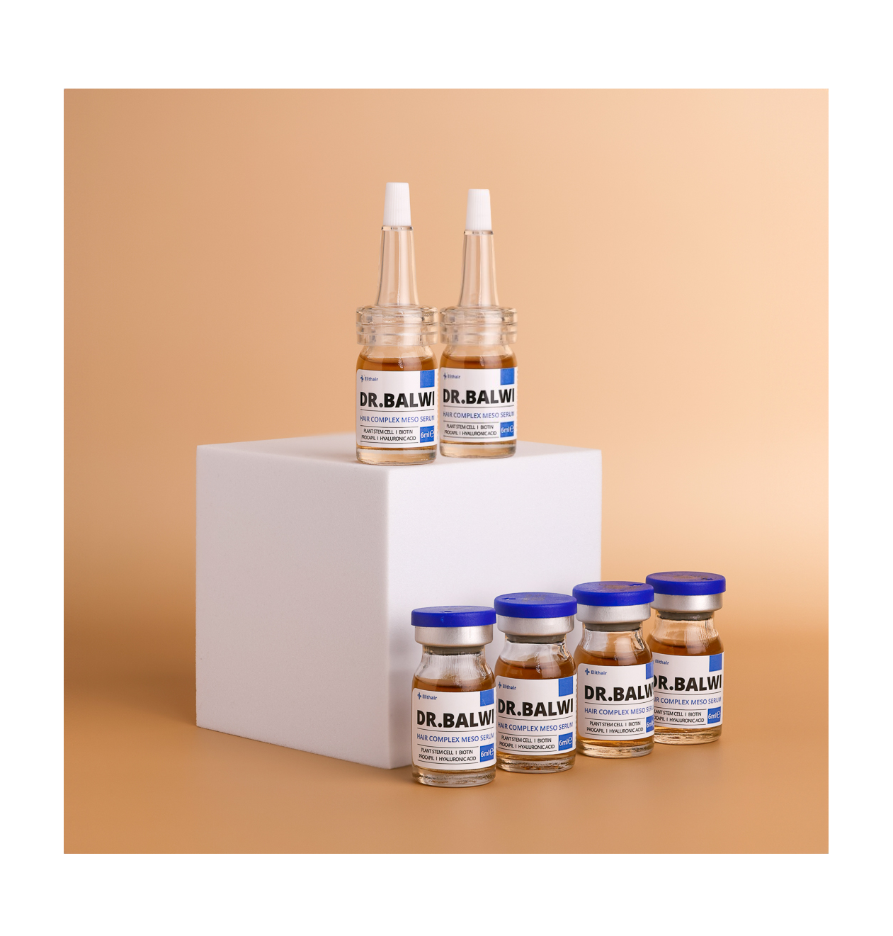 Sechs Fläschchen aus dem Dr. Balwi Hair Boost Set von shop.elithairtransplant sind um einen weißen Würfel angeordnet: Zwei mit weißen Tropfern sitzen auf dem Würfel, während vier Fläschchen mit normalem Deckel mit Procapil™ und AnaGain™ davor auf einem beigen Hintergrund stehen.