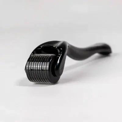 Eine Nahaufnahme des Dr. Balwi Dermarollers von shop.elithairtransplant mit schwarzem Griff und mehreren feinen Metallnadeln auf seinem rotierenden Kopf für Microneedling, platziert auf einer weißen Oberfläche.