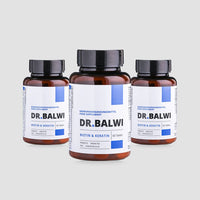 Auf drei braunen Nahrungsergänzungsmittelflaschen mit schwarzen Deckeln steht in blau-schwarzer Schrift „shop.elithairtransplant Biotin & Keratin Tabletten“ und steht auf einem schlichten hellgrauen Hintergrund.