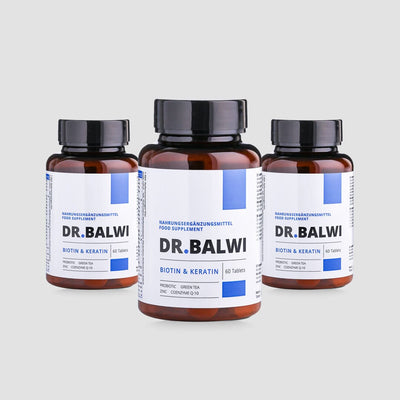 Drei braune Flaschen Dr. Balwi Shop Biotin & Keratin Tabletten, jede mit einem weiß-blauen Etikett und 60 Tabletten, sind vor einem schlichten hellgrauen Hintergrund abgebildet.