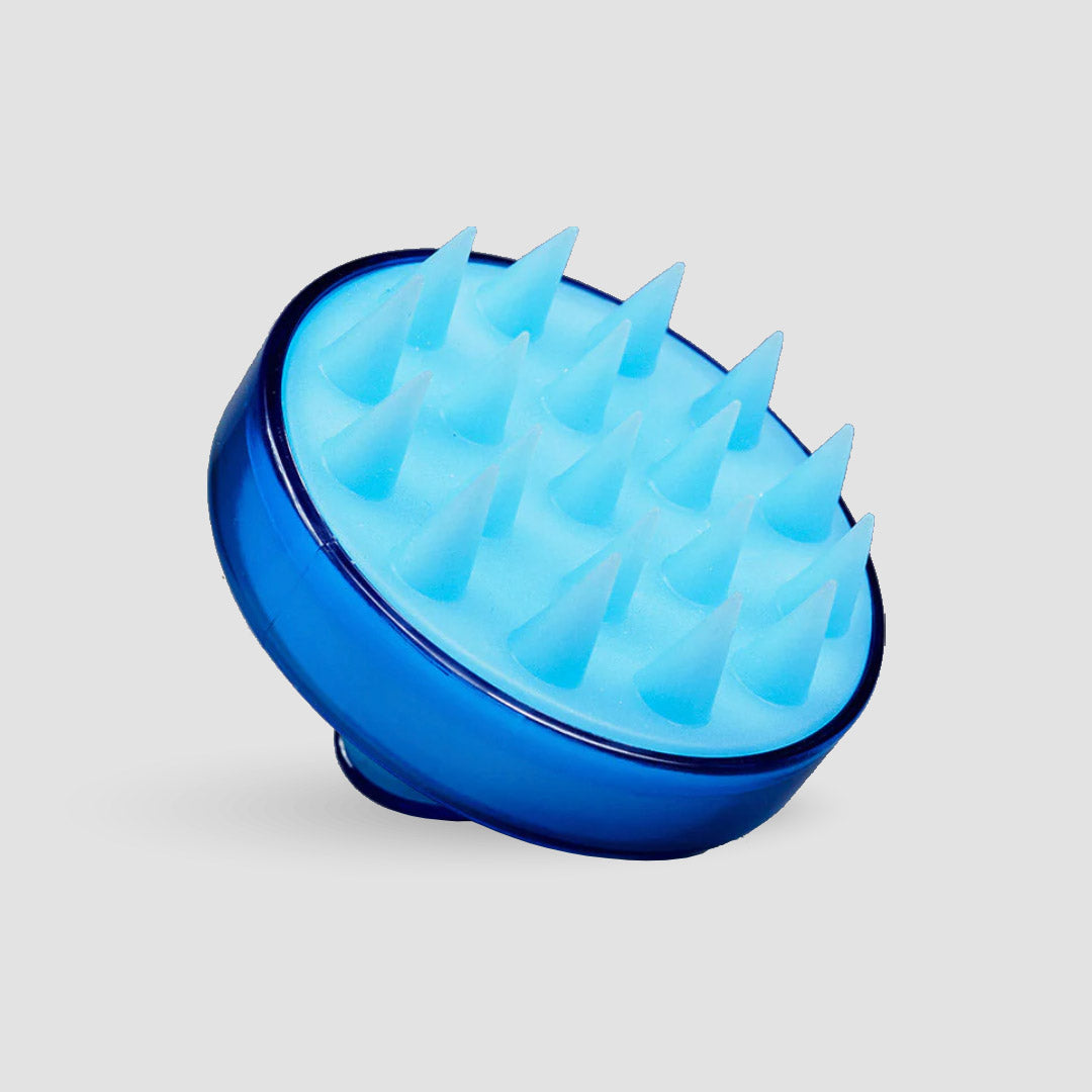 Die Anti-Haarausfall-Routine von shop.elithairtransplant besteht aus einem blauen Kopfhautmassagegerät aus Silikon mit runder Basis und weichen, abgewinkelten Borsten, die auf einem schlichten hellgrauen Hintergrund abgebildet sind.