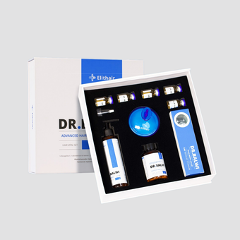 Ein geöffnetes Dr. Balwi Haar-Vital-Set aus dem Dr. Balwi Shop zeigt in einer weiß-blauen Schachtel fein säuberlich angeordnete Flaschen, Fläschchen, eine Pipette, ein Serum, einen Applikator und ein Anleitungsheft.