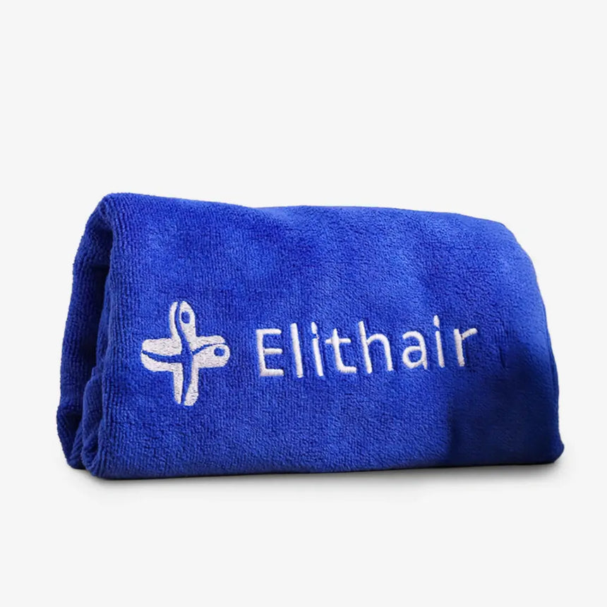 Ein gefaltetes blaues Mikrofaser-Kopfhandtuch aus dem Dr. Balwi Shop mit dem Schriftzug "Elithair" und einem weißen gestickten Logo auf einer Seite, das auf einem schlichten weißen Hintergrund abgebildet ist.